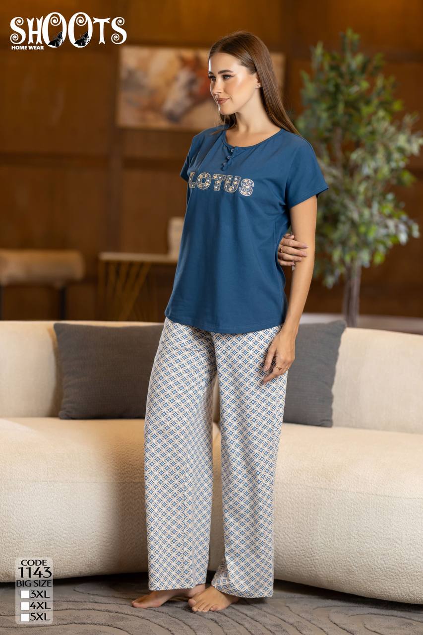 Woman wearing a blue 'LOTUS' t-shirt and patterned pants in a living room setting.