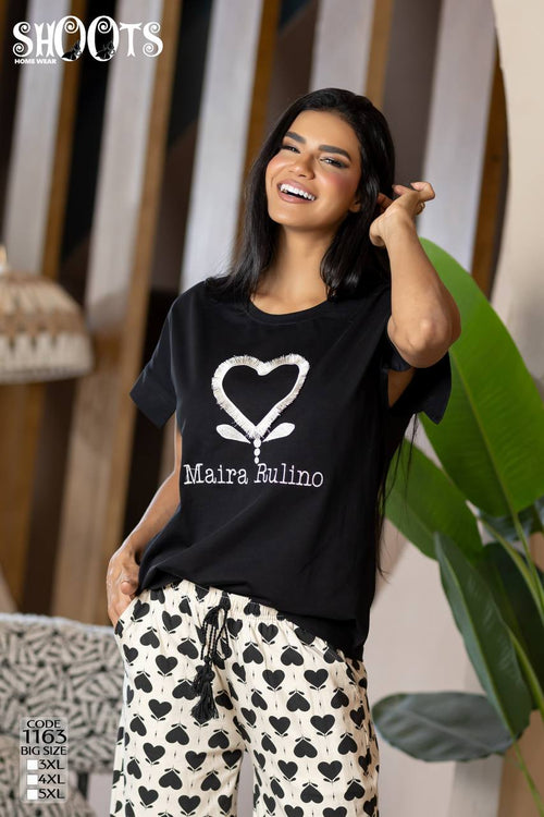 Woman wearing a black t-shirt with a white heart design and text, standing indoors.